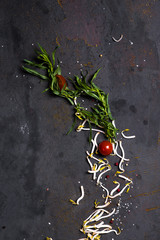 Cherry tarragon greens and spices on a dark background