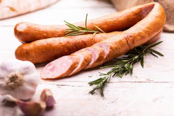 Rings of traditional, country, homemade, smoked sausage on wood boards. Rustic composition with...
