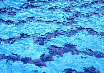The water surface of the swimming pool turquoise color, illuminated by the sun