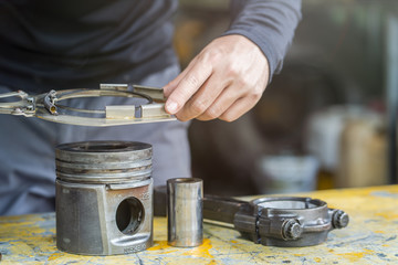 mechanic man using clamping piston ring tool  to remove and install piston ring,  mechanical maintenance and repair background