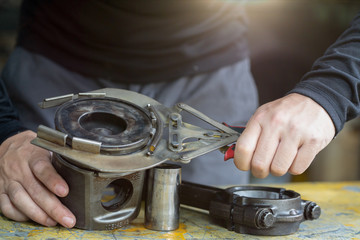 mechanic man using clamping piston ring tool  to remove and install piston ring,  mechanical maintenance and repair background