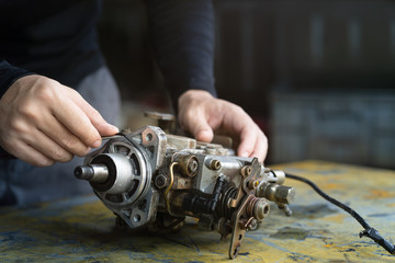 Mechanic man trying to remove o-ring seal of diesel injection pump,  mechanical maintenance and repair background