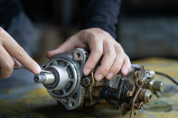 Mechanic man trying to remove seal shaft  of diesel injection pump,  mechanical maintenance and repair background