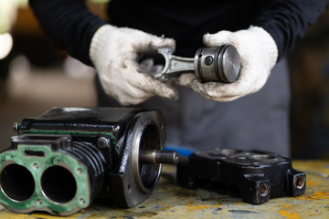 Piston of air compressor pump on mechanic man, Mechanical maintenance and repair background
