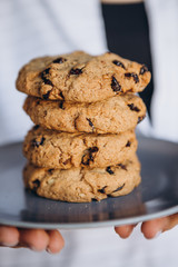close up photo of delicious and crunchy oatmeal cookies on the backdrop of a cozy restaurant or bakery interior, festive Christmas mood, 4 cookies lying on top of each other
