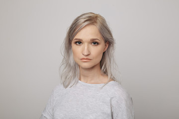 Portrait of young woman with cute face posing in the white studio isolated