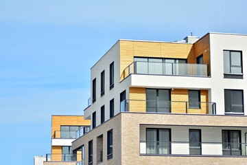 Contemporary residential building exterior in the daylight. Modern apartment buildings on a sunny day with a blue sky. Facade of a modern apartment building
