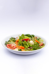 white deep plates with fresh salad ingredients mixed with sauce placed on isolated white background. A place for a menu, banner or advertisement