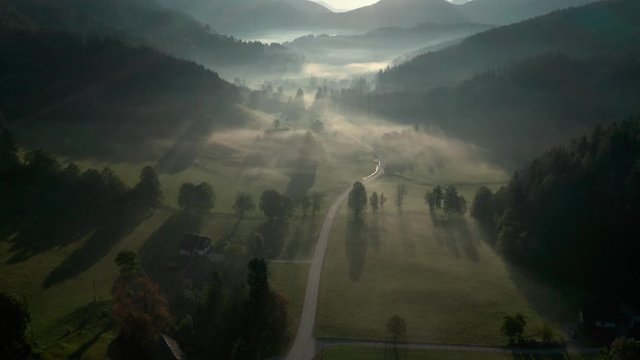 Zell Pfarre misty  village and valley shadowy landscape, Slovenia border aerial view rising above scenery.