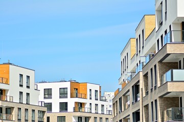 Contemporary residential building exterior in the daylight. Modern apartment buildings on a sunny day with a blue sky. Facade of a modern apartment building