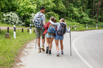 Obraz premium Group of friends hiking in nature.They walking by the old country road.