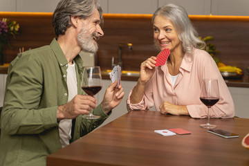 Two gleeful mature people holding their cards