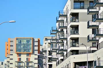 Contemporary residential building exterior in the daylight. Modern apartment buildings on a sunny day with a blue sky. Facade of a modern apartment building