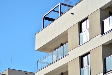 Contemporary residential building exterior in the daylight. Modern apartment buildings on a sunny day with a blue sky. Facade of a modern apartment building