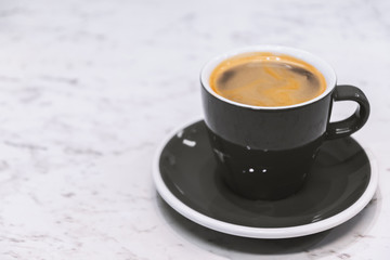 Coffee Espresso. Black Ceramic Cup Of Coffee on white stone table background.