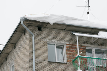 Snow and icicles hang from the roof