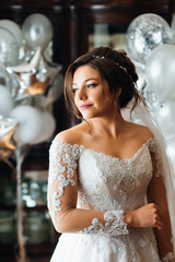 Naklejka premium Beautiful girl in a wedding dress on the background of room with