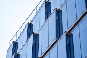 Fototapeta premium Na zewnątrz współczesnego budynku mieszkalnego w świetle dziennym. Nowoczesne budynki mieszkalne w słoneczny dzień z błękitnym niebem. Fasada nowoczesnego apartamentowca