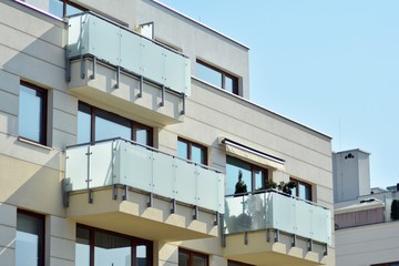 Contemporary residential building exterior in the daylight. Modern apartment buildings on a sunny day with a blue sky. Facade of a modern apartment building