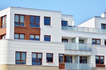 Contemporary residential building exterior in the daylight. Modern apartment buildings on a sunny day with a blue sky. Facade of a modern apartment building
