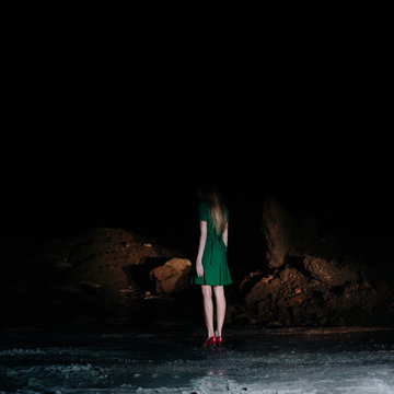 Girl with green dress alone on dark road
