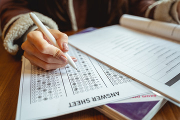 Obraz premium Young female person completing task before exams