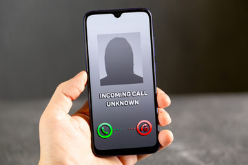 Phone call from unknown number. Scam, fraud or phishing with smartphone concept. Prank caller, scammer or stranger. Woman answering to incoming call. Hoax person with fake identity