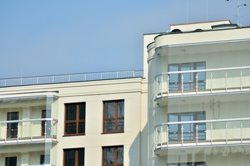 Contemporary residential building exterior in the daylight. Modern apartment buildings on a sunny day with a blue sky. Facade of a modern apartment building