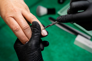 woman in a nail salon receiving a manicure by a beautician