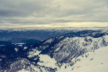 Spectacular winter mountain panoramic view of mountains with clouded sky.