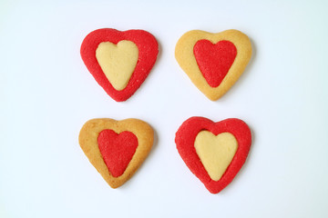 Naklejka na ściany i meble Four of vibrant color heart shaped two tone butter cookie on white background