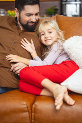 Adorable little girl spending time with father at home