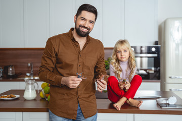 Cheerful father and daughter playing with toys at home