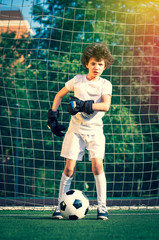 Summer soccer tournament for young kids. football club. emotions and joy of the game. Young goalie. Kids - soccer champion. Boy goalkeeper in football sportswear on stadium with ball. Sport concept.