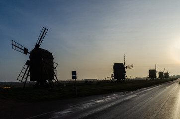 Old wooden windmill silhouettes in a row