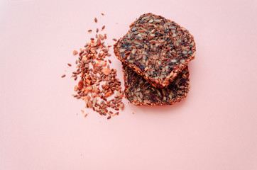 Sliced whole grain bread rye with seeds flax, sunflower, pumpkin and sesame.Healthy food, eco-friendly natural products. Fresh bread on a pink background.