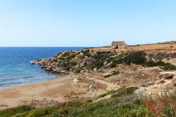 Fototapeta na wymiar Northern Cyprus travel. The ruins of an ancient building on the island. Summer seashore with transparent blue water. Seascape. Skyline.