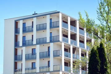 Contemporary residential building exterior in the daylight. Modern apartment buildings on a sunny day with a blue sky. Facade of a modern apartment building