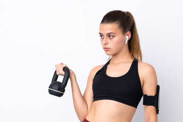 Teenager sport girl over isolated white background making weightlifting with kettlebell