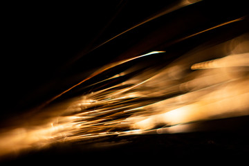 fast-flying sparks from angle grinders close-up, front and background blurred with bokeh effect