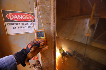 Certified miner hands holding inspecting gas test detector its continue monitoring at entry...