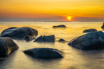 Fototapeta na wymiar Beautiful golden hour glowing sunshine during the setting sun creating an ocean seascape.