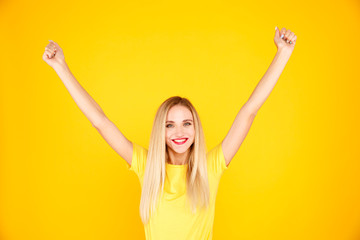 Attractive woman winner isolated in the yellow studio