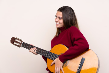 Fototapeta premium Teenager girl with guitar over isolated background looking side