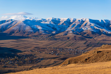 Amazing snowy mountain landscape with settlements, Armenia
