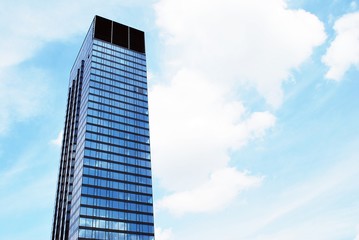 Obraz premium Abstrakcyjny obraz patrząc na nowoczesny budynek ze szkła i betonu. Architektoniczny detal zewnętrzny budynku biurowego.