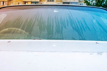 wet the windshield of the car after the rain is not rubbed by the wipers at sunset