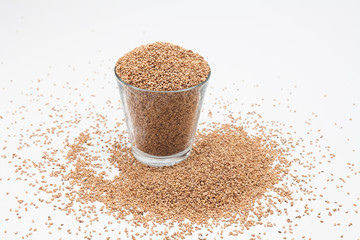 Sesame seeds in glass cup on a white