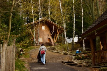A woman walking uphill with a stroller on her way to a fairy-tale village in the Czech Republic