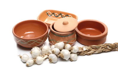 Empty clay food bowls with garlic isolated on white background